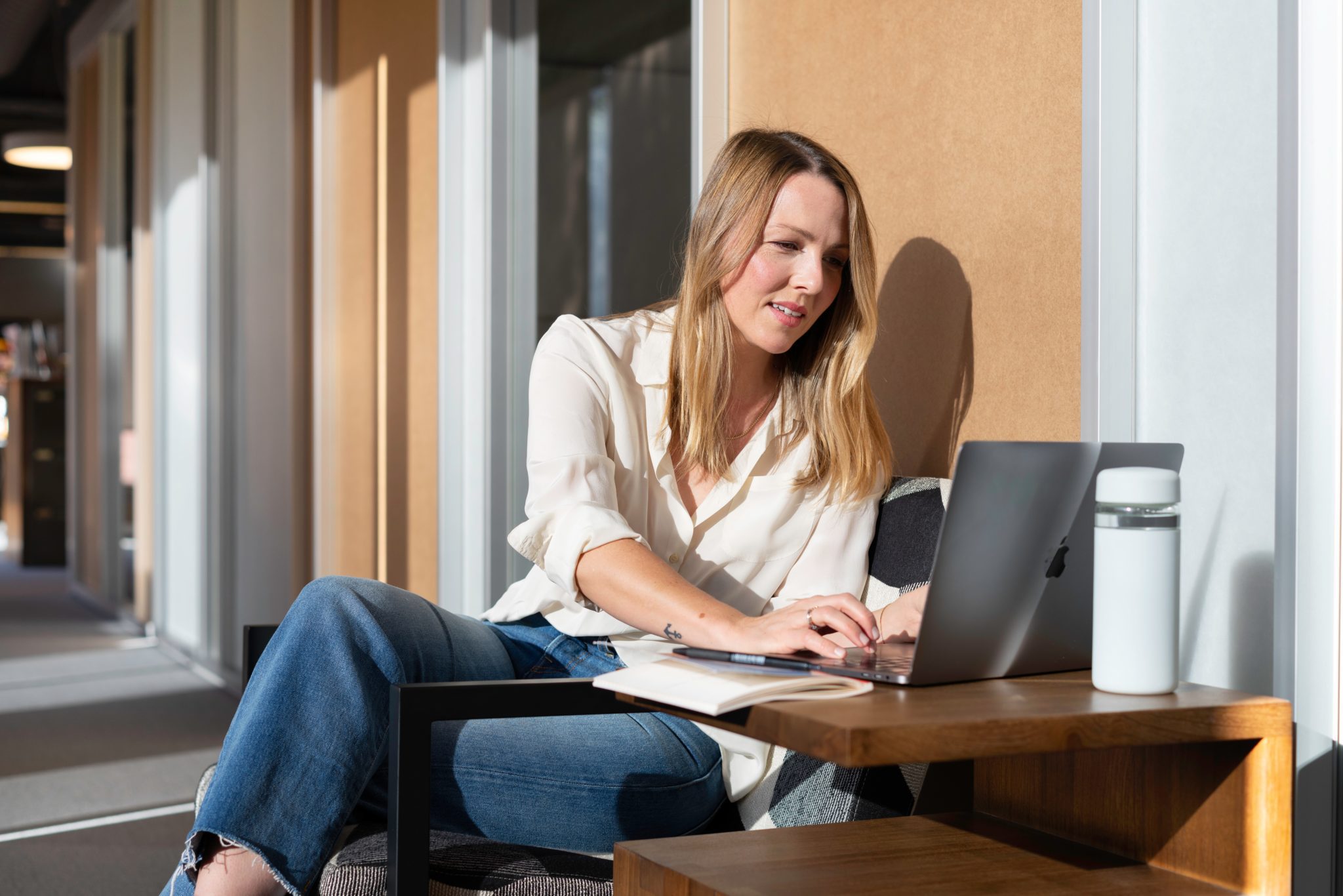 Woman on balcony doing vision planning on laptop